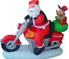 Раздувное Санта и олени сидя на зеленом велосипеде мотора