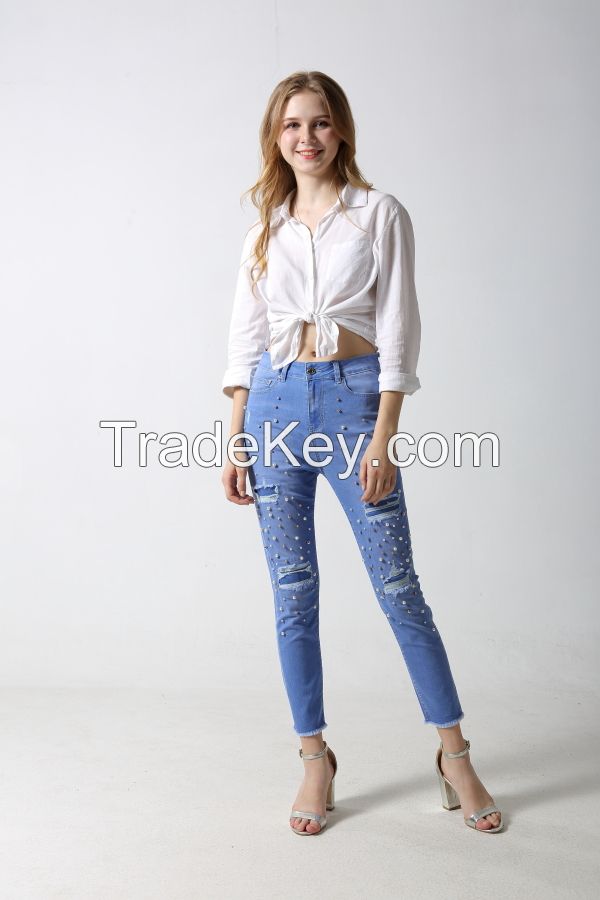 Woman's slim denim jeans with distress patches with studs