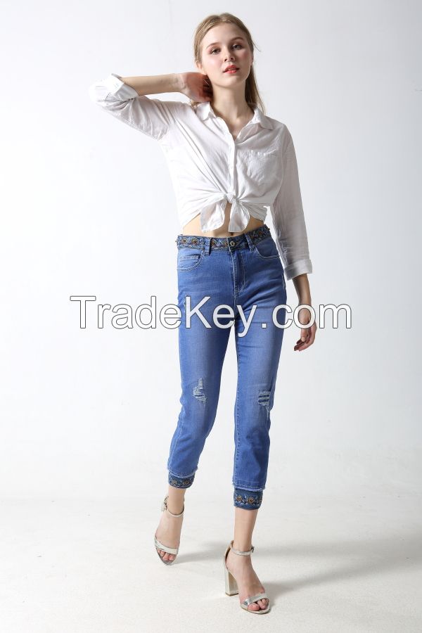 Woman's denim capril with emboridery at waistband and hem