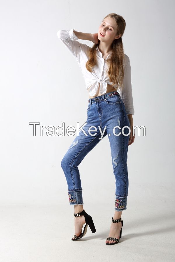 Woman's denim jeans with sparkling at waistband and hem