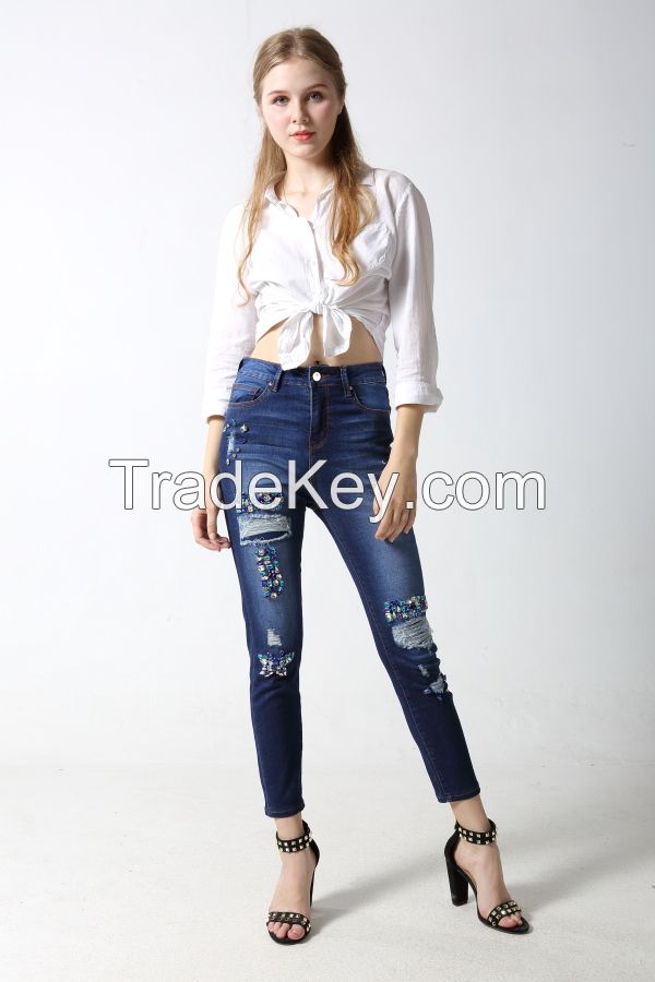 Woman's slim denim jeans with distressed and sparkling