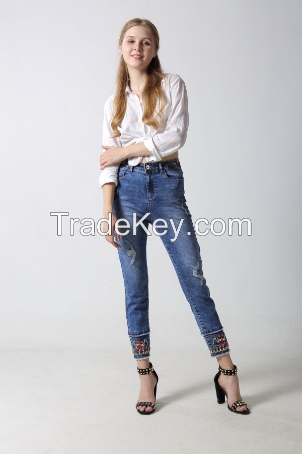 Woman's denim jeans with sparkling at waistband and hem