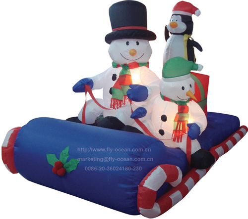 2 inflatable Snowmem and penguin sitting on blue sleigh