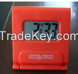 Travelling alarm clock with foldable stand