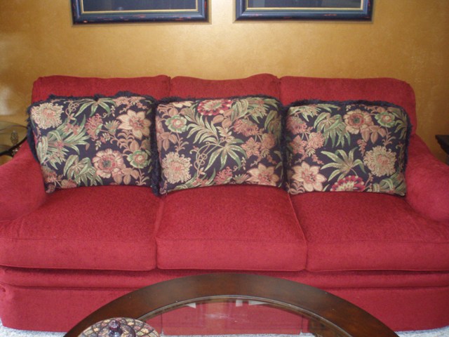 red chenille sofa with black tapestry pillows