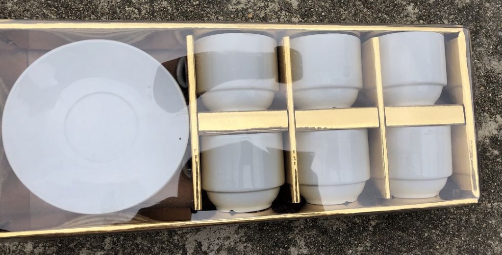 Ceramic white coffee cup and saucer with golden box packing 