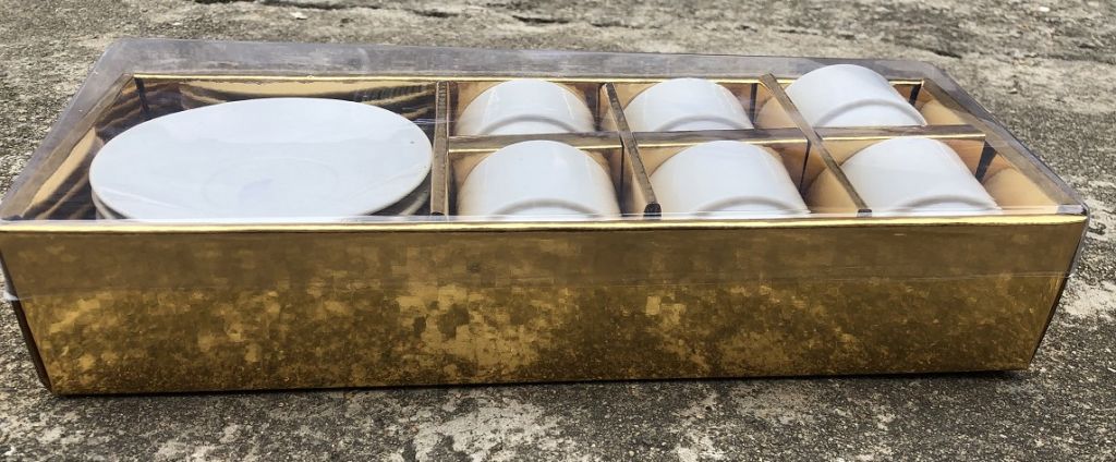 Ceramic white coffee cup and saucer with golden box packing 