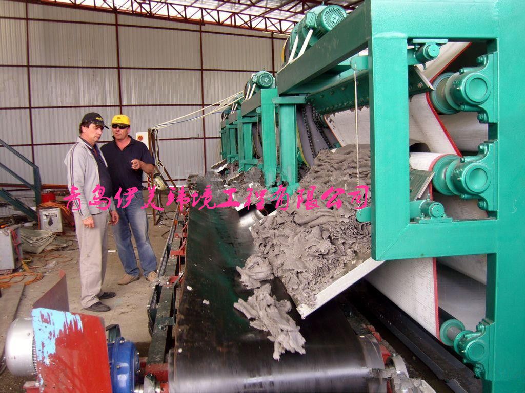 Solid material dewatering belt filter press