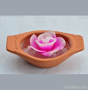 Rose candle in a clay Thai paddling boat