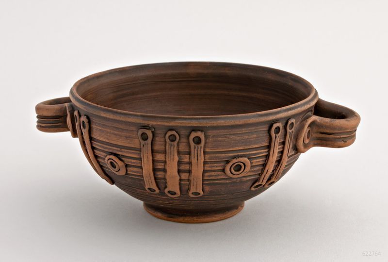 Ceramic bowl with handles made of red clay. 