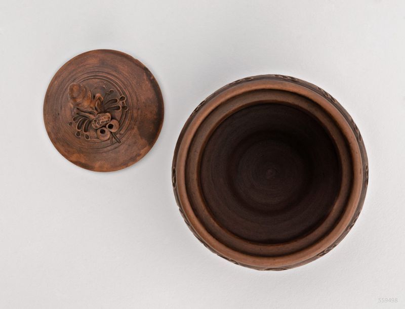 Brown ceramic pot with lid for honey made of red clay.