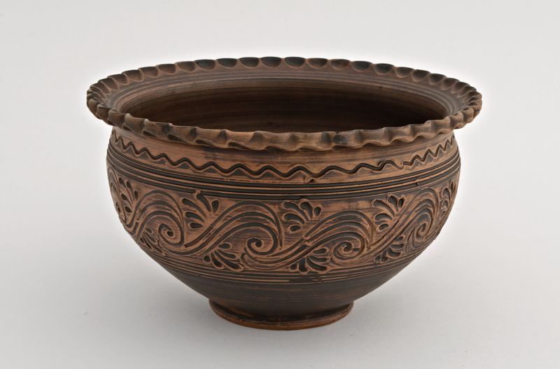 Ceramic brown bowl formed by hand out of red clay.