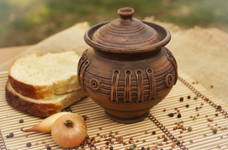 Ceramic pot with lid for cooking made of red clay.