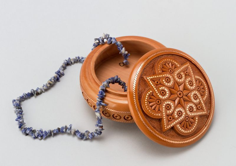 Round wooden jewelry box with hand carved pattern and metal inlay