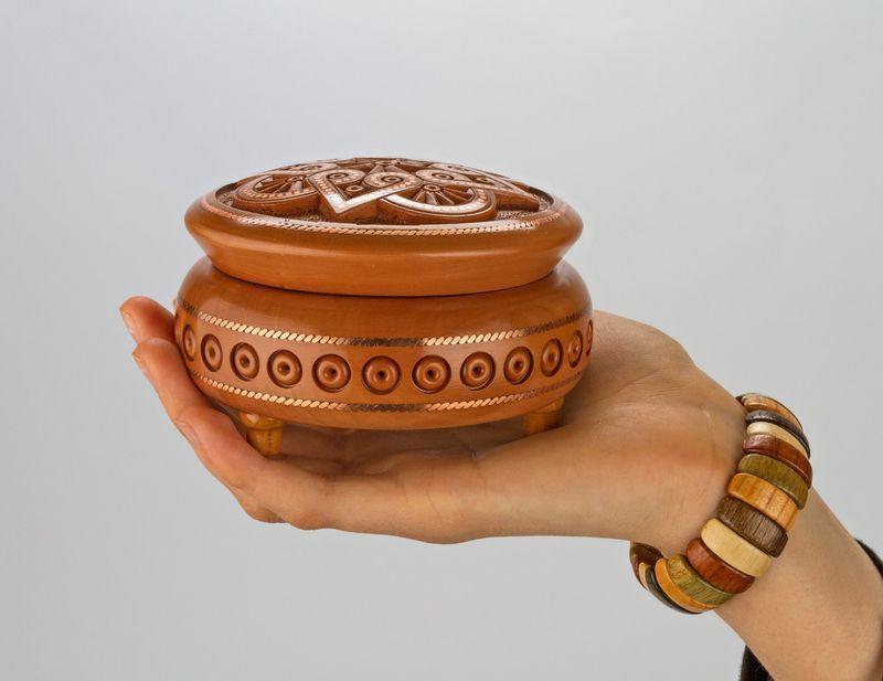 Round wooden jewelry box with hand carved pattern and metal inlay