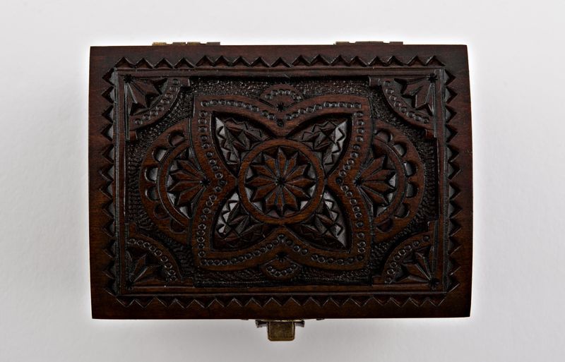 Wooden jewelry box with hand carved pattern.