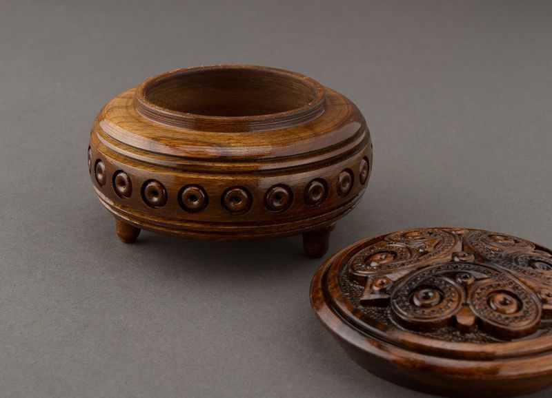 Hand carved round wooden brown jewelry box.