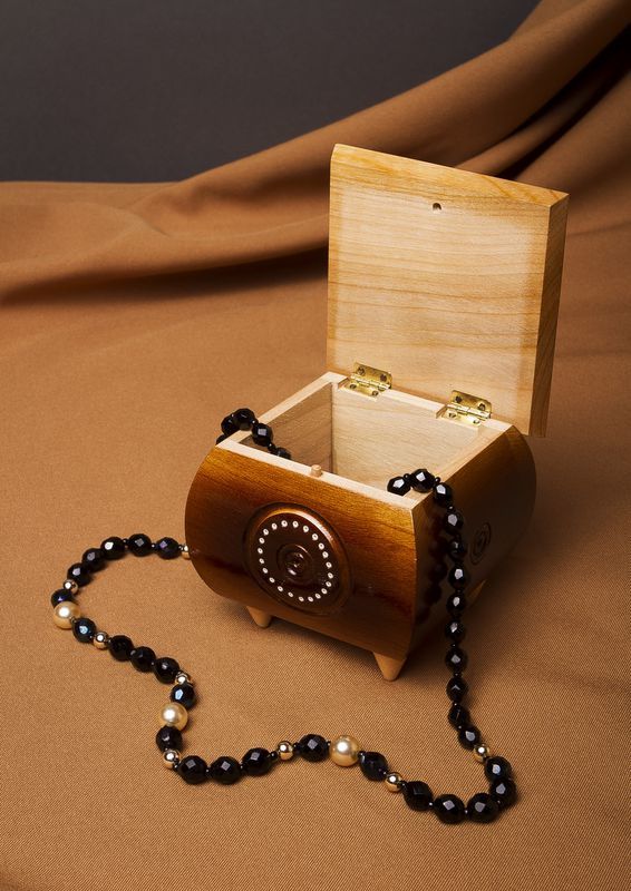 Varnished carved jewelry box inlaid by beads.