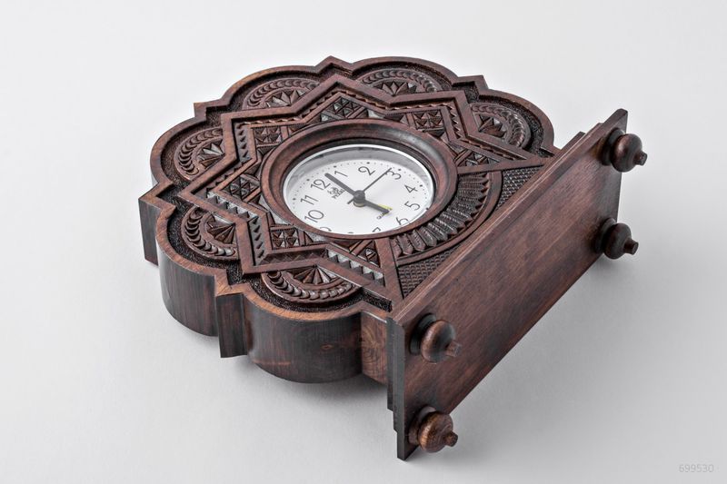 Wooden alarm clock with hand carved pattern.