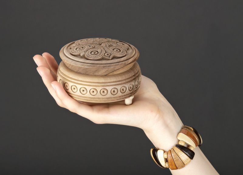 Round wooden jewelry box with hand carved pattern.