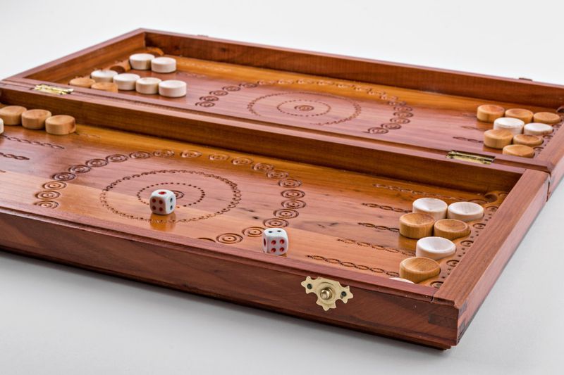 Wooden backgammon with hand carved pattern.