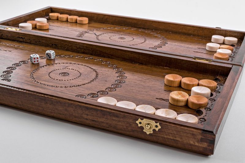 Wooden backgammon with hand carved pattern.