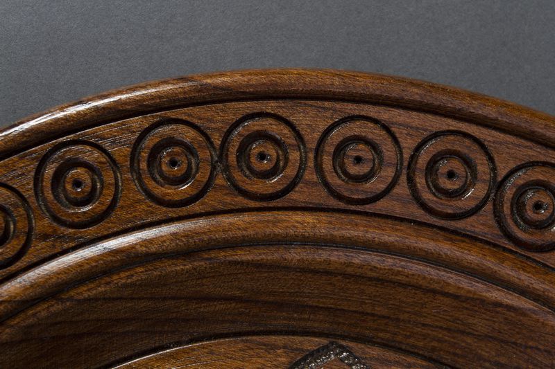 Handmade wall wooden plate with carved pattern.