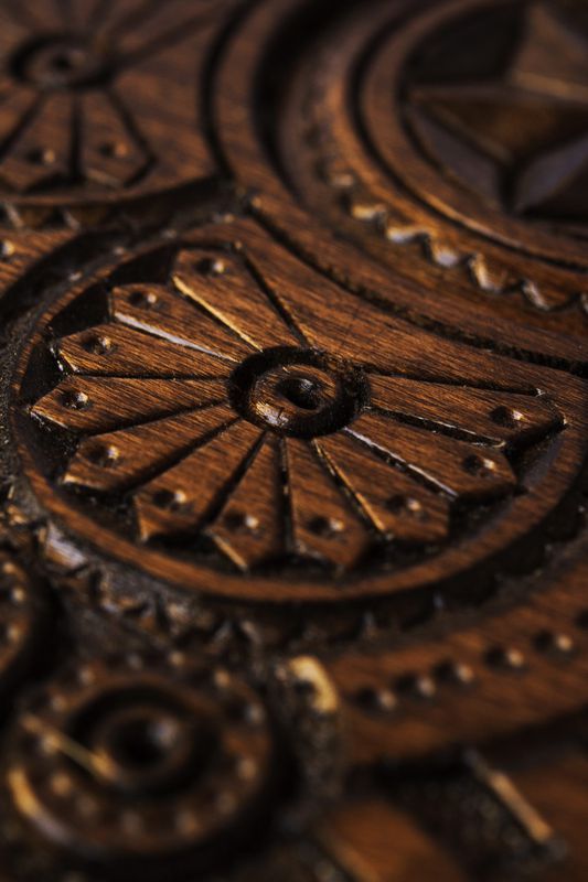 Handmade wall wooden plate with carved pattern.