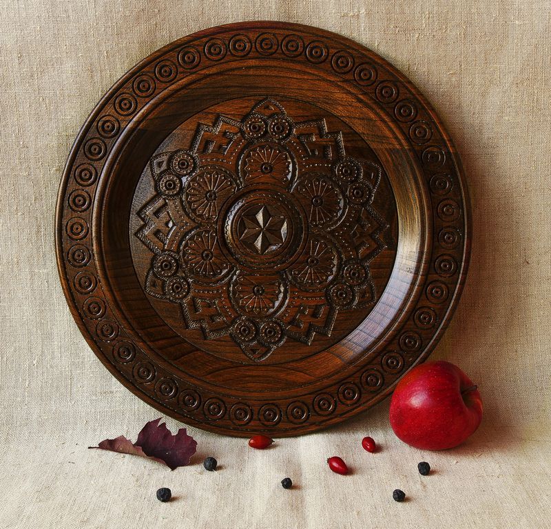 Handmade wall wooden plate with carved pattern.