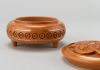 Round wooden jewelry box with hand carved pattern and metal inlay