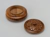 Round wooden jewelry box with knob handle and hand carved pattern.