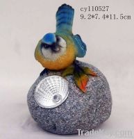 resin bird on stone with light