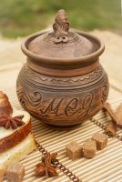 Brown ceramic pot with lid for honey made of red clay.