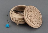 Round wooden jewelry box with hand carved pattern. 