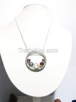 Silver pendant set with one moon stone and four garnets